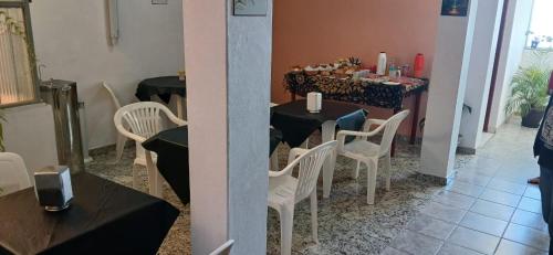 une salle à manger avec une table et des chaises blanches dans l'établissement Pousada Silva Guedes, à São Thomé das Letras