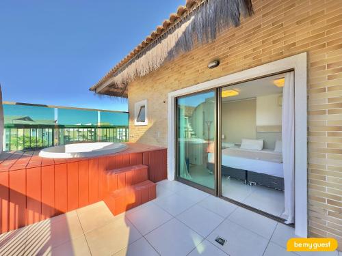 a room with a balcony with a bed and a tub at Parque das Ilhas in Mangabeira