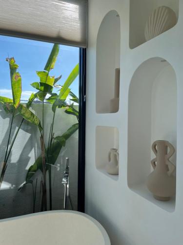 a bathroom with a white toilet and a window at White Shell Villas in Uluwatu
