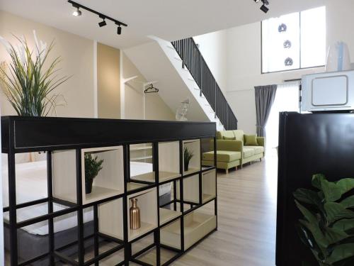 a living room with a black shelf with plants at Emporis Kota Damansara PJ by Sleepy Bear in Petaling Jaya