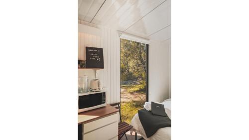 a room with a window and a bed and a desk at Mirror Reflections by Tiny Away in Tamborine