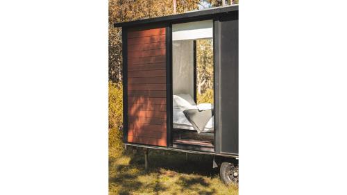 a tiny house with a window on a trailer at Mirror Reflections by Tiny Away in Tamborine