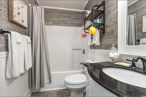 a bathroom with a sink and a toilet and a tub at First floor, Little River Condo with Pool 3 miles from beach in Little River