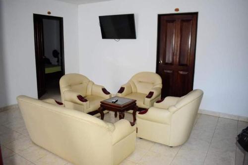 a living room with three couches and a table at Hotel La Estación Campestre in Curití