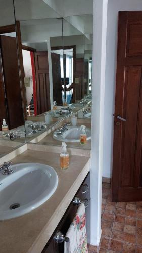 a bathroom with two sinks and a large mirror at Casa a 800 mts de pleno centro - NO RECIBO GRUPO DE JOVENES in Villa Carlos Paz