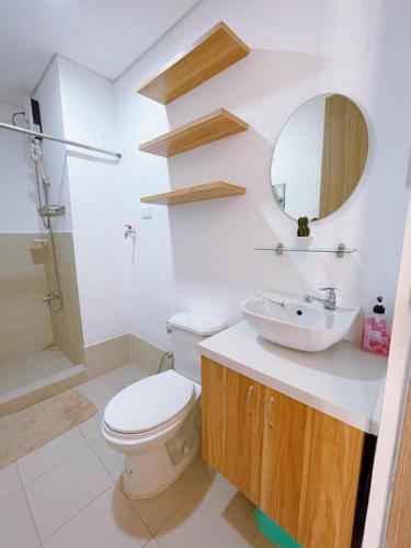 a bathroom with a toilet and a sink and a mirror at Eco Suite Hope Residences Trece in Trece Martires