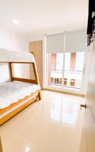 a bedroom with a bunk bed and a large window at Casa frente al mar con piscina in Coveñas