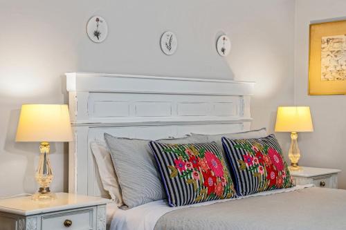 a bedroom with a bed with two tables and two lamps at Withycombe, Bowral in Bowral