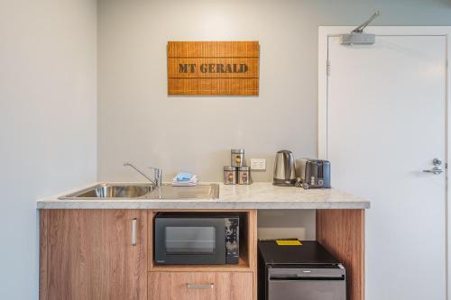 a kitchen with a sink and a microwave at Woolshed Suites in Lake Tekapo