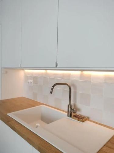 un comptoir de cuisine avec un évier dans une cuisine dans l'établissement Au PIED de la MER Au COEUR de la station Beau Duplex contemporain tout confort 50m2, à Bénodet