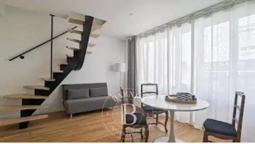 un salon avec un escalier et une table dans l'établissement Au PIED de la MER Au COEUR de la station Beau Duplex contemporain tout confort 50m2, à Bénodet