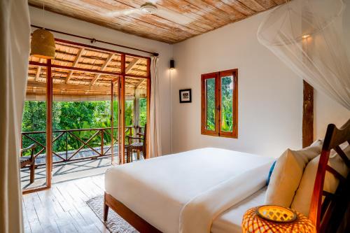 a bedroom with a bed and a large window at My Dream Boutique Resort in Luang Prabang