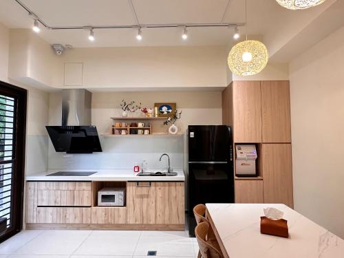 a kitchen with a black refrigerator and a table at Holi homestay in Houli