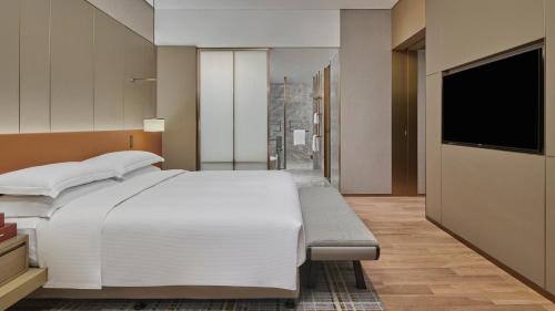 a bedroom with a large white bed and a flat screen tv at DoubleTree by Hilton Jiangxi Fuzhou in Fuzhou