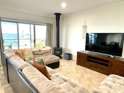 a living room with a couch and a flat screen tv at Africaine Voyage in Kingscote