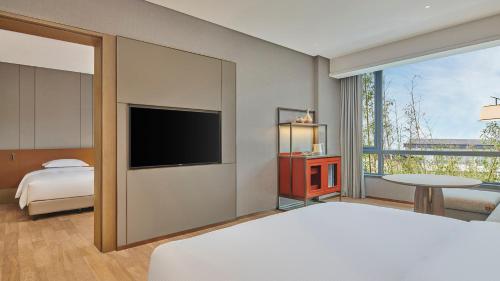 a bedroom with a bed and a flat screen tv at DoubleTree by Hilton Jiangxi Fuzhou in Fuzhou