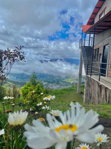 a view of a building with flowers in front of it at Inti Amanta Lodge in Sigchos