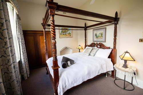 a bedroom with a bed with a dog laying on it at The Residence of MacKenzie Quarters CBD Bendigo in Bendigo