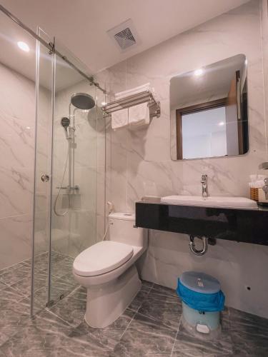 a bathroom with a toilet and a sink and a shower at Blue Sea Hotel in Cam Lâm
