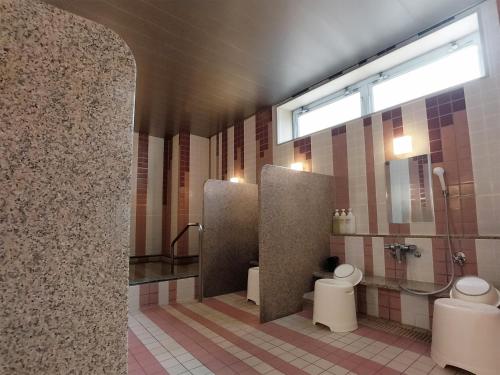 a public bathroom with two toilets and a window at Green Rich Hotel Nagoya Nishiki (Artificial hot spring Futamata Yunohana) in Nagoya