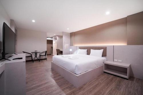 a bedroom with a large white bed and a table at The Y House in Chiang Mai