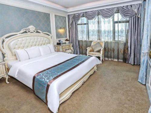 a bedroom with a large bed and a chair at Chang An Hotel in Shenzhen