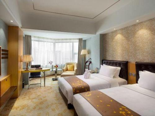 Una habitación de hotel con dos camas y un escritorio. en Xian Empress Hotel, en Xi'an