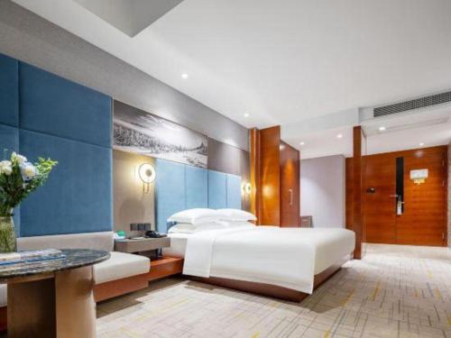 a bedroom with a white bed and a blue wall at Wuhan Tieqiao Jianguo Hotel in Wuhan