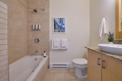 a bathroom with a tub and a toilet and a sink at Liahona Guest House in Ucluelet