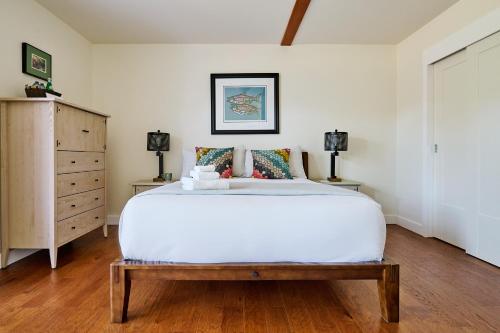 a bedroom with a large white bed and two lamps at Liahona Guest House in Ucluelet
