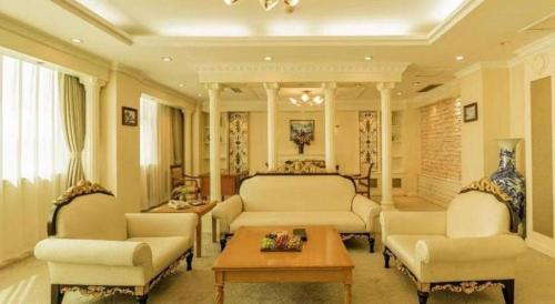 a living room with two chairs and a table at Jincheng Pacific Hotel in Jincheng