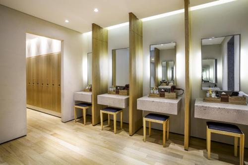 a bathroom with three sinks and two mirrors at Maison Glad Jeju in Jeju