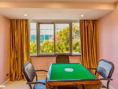 a conference room with a green table and chairs at Dali Dayu Hotel in Dali