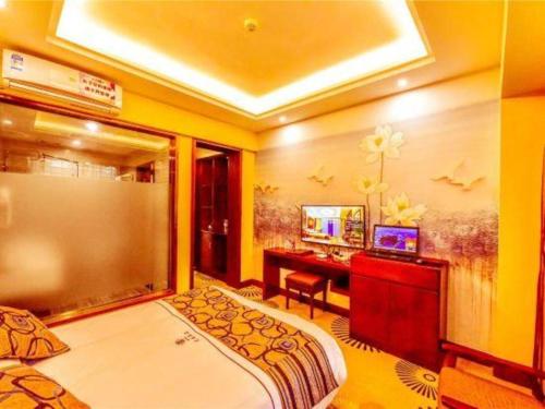 a bedroom with a bed and a desk with a television at Dali Dayu Hotel in Dali