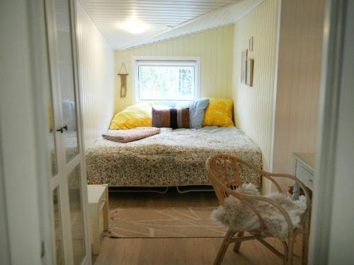a small bedroom with a bed and a window at Summer House With Cozy Garden Near The Beach in Glesborg