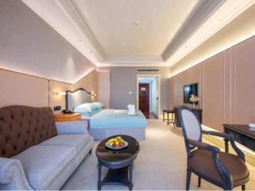 a hotel room with a couch and a bed at Zhejiang D.H Hotel in Jiaxing
