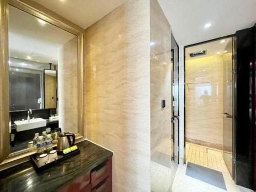a bathroom with a shower and a sink and a mirror at Wuhan Gaotie Kairui International Hotel in Wuhan