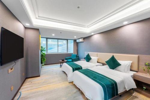 a bedroom with two beds and a flat screen tv at Wuhan Yamao Hengsheng Hotel in Wuhan
