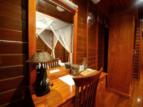 a room with a wooden desk with a window at Phimai Paradise House in Pi Mai