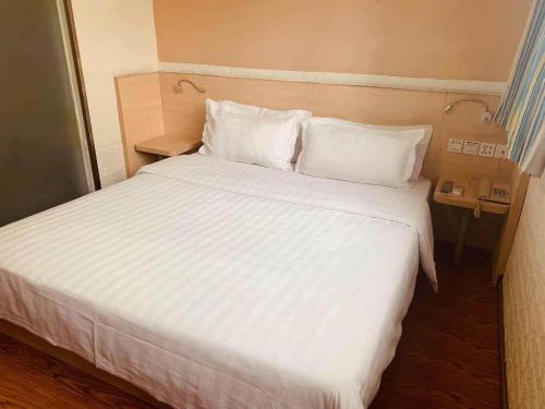 a large white bed in a hotel room at 7 Days Inn Chengdu North Railway Metro Station in Chengdu