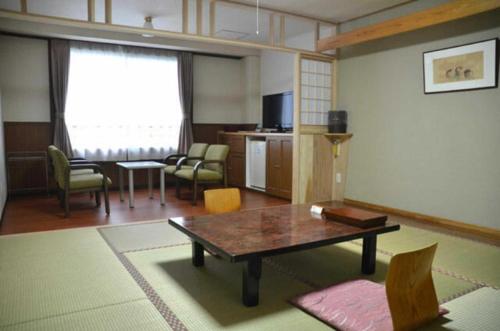 a living room with a coffee table and chairs at Kirishima Onsen Ryokojin Sanso in Kirishima