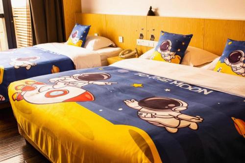 a hotel room with two beds with hello kitty blanket at Xian Elegant Oriental Hotel in Xi'an