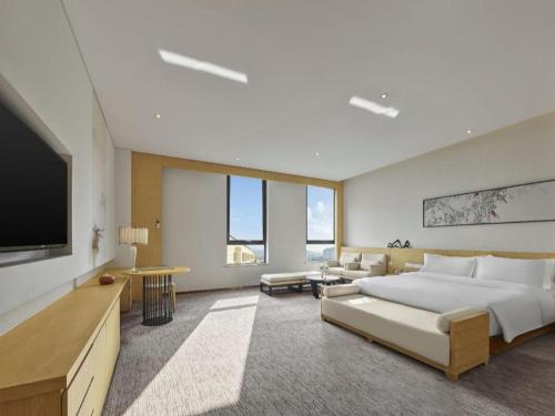 a large bedroom with a large bed and a flat screen tv at Xian Elegant Oriental Hotel in Xi'an