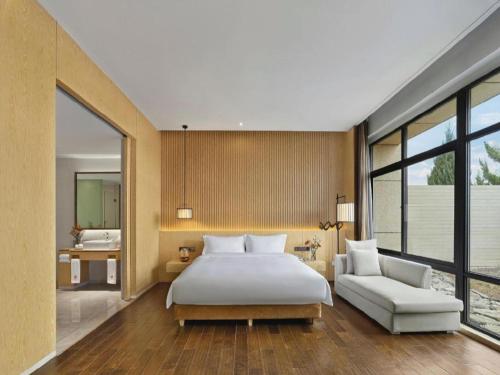 a bedroom with a large bed and a white couch at Xian Elegant Oriental Hotel in Xi'an
