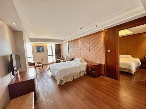 a hotel room with two beds and a television at Auspicious Hotel in Zhongshan