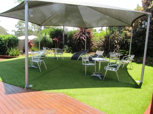 a group of tables and chairs under an umbrella at Highfields Motel Toowoomba in Highfields