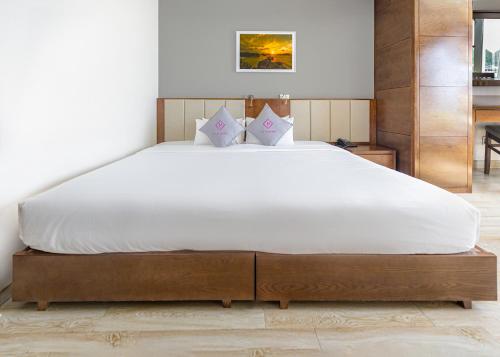 a bedroom with a large bed with white sheets at Cat Ba Paradise Hotel - Sky Bar & Massage in Cat Ba