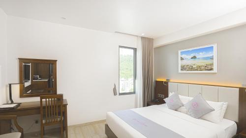 a bedroom with a bed and a desk and a computer at Cat Ba Paradise Hotel - Sky Bar & Massage in Cat Ba