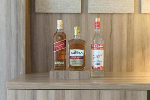 three bottles of alcohol sitting on top of a shelf at EXCELLENCE PUNTA CANA - ALL INCLUSIVE - ADULTS ONLY in Punta Cana