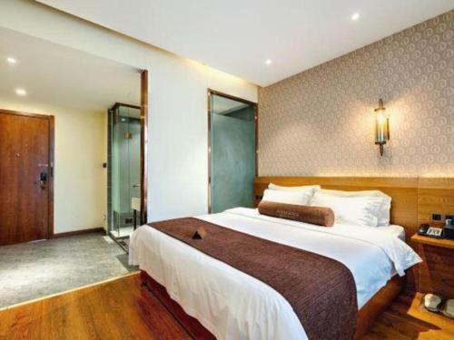 a bedroom with a large bed and a shower at James Joyce Coffetel Qufu Tourist Center Gulou Street Sankong Scenic Spot in Jining